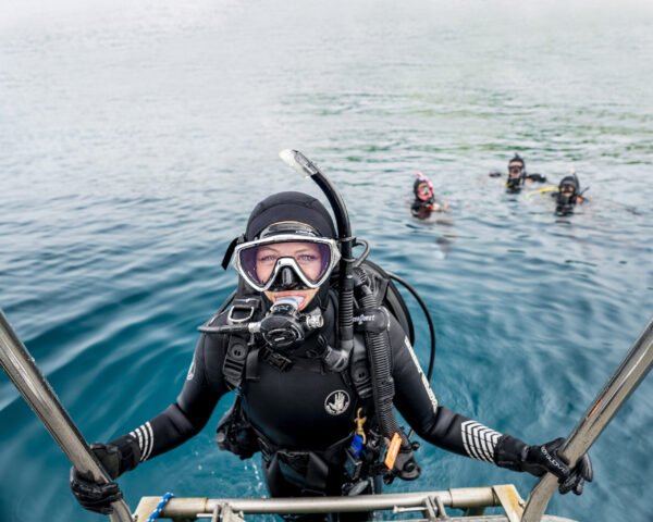 Scuba diver climbing the boat ladder after a dive